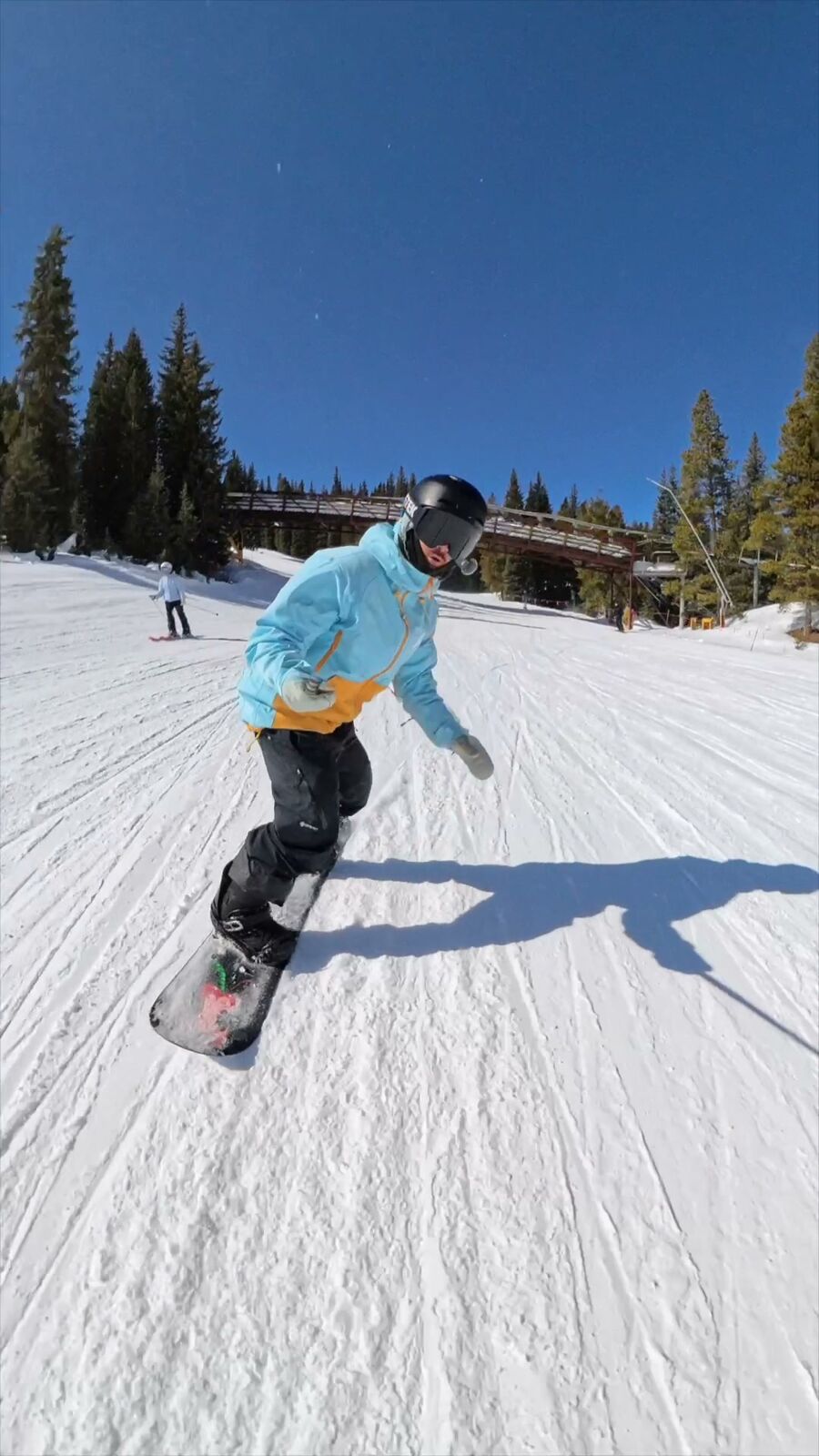 Snowboarder carving toward the camera